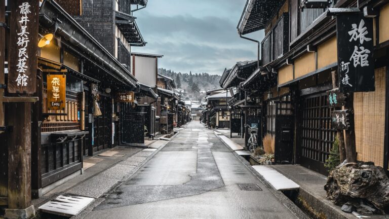 牛肉與飛驒 a narrow street in an asian city with snow on the ground