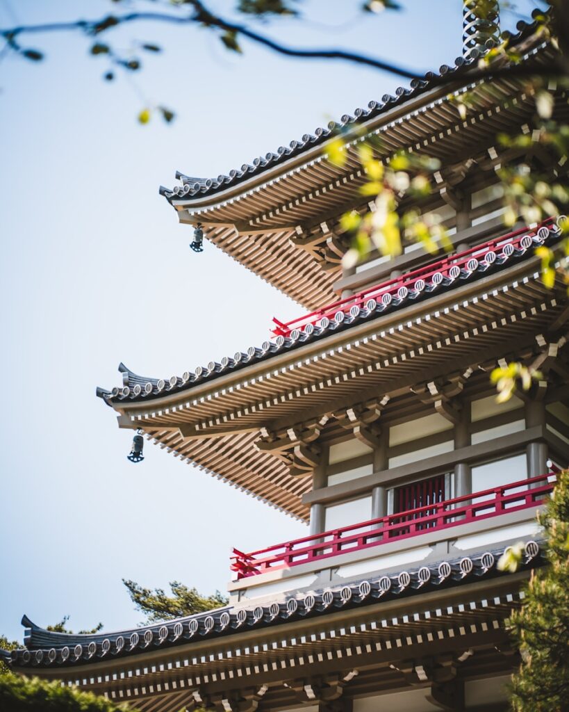 伊達政宗與仙台 a tall building with a red roof and a sky background