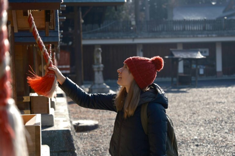 冷麵與盛岡 a woman wearing a red hat and holding a red string