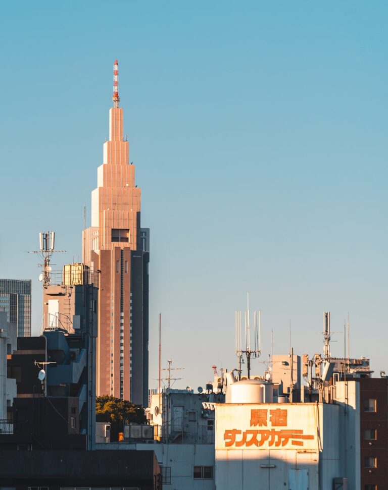 日本的四大電信業者 Dramatic view of Tokyo's skyline with NTT DoCoMo Yoyogi Building against a clear sky.