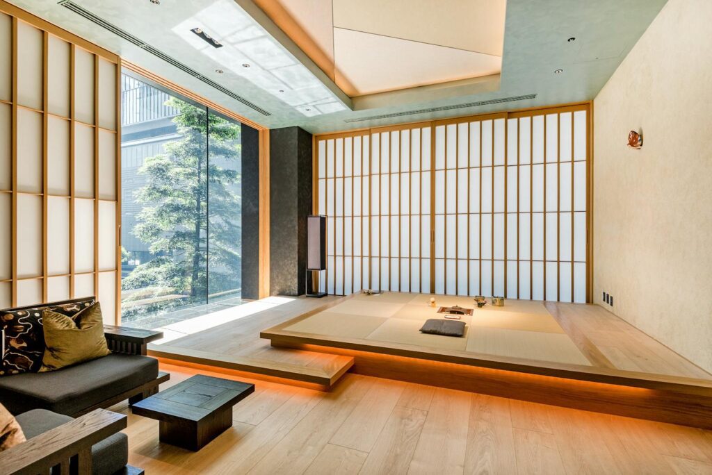 日本airbnb的特色 Bright and spacious Japanese living room featuring a modern tatami area and large windows with natural light.