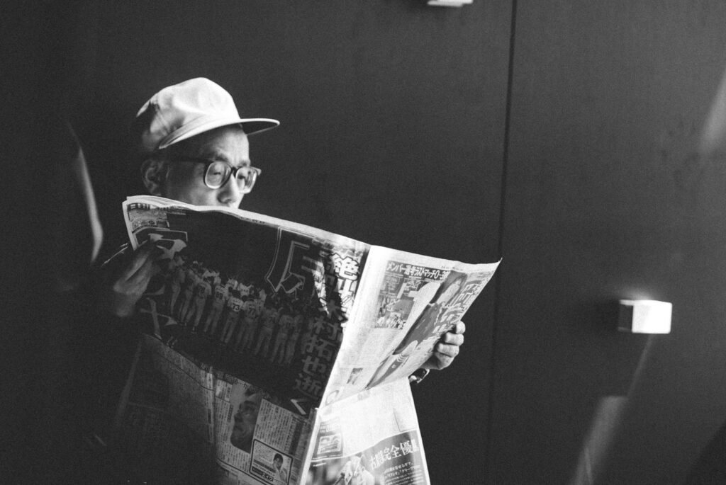 日本旅遊新聞2025-03-22 man in black shirt reading newspaper